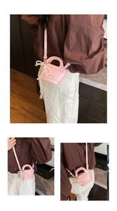 Detailed view of mini pink bucket bag with pearl bow and white lace ribbon decor
