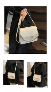 Detailed macro view of white crocodile pattern shoulder bag with silver chain and pearl