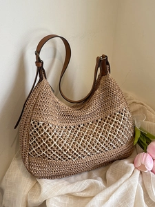 Bohemian hollow woven straw tote bag with brown leather straps on aesthetic background