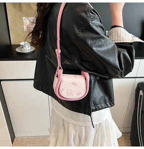 Détail du mini sac selle rose avec imprimé ours cartoon et bandoulière assortie