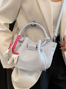 Fashionable light blue crocodile embossed bucket bag with a pegasus charm and shoulder strap