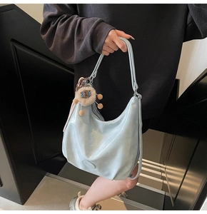Détail du sac hobo bleu clair brillant avec bandoulière et breloque peluche mignonne