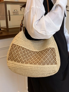 Hollow straw woven shoulder tote bag with brown leather strap for beach vacations