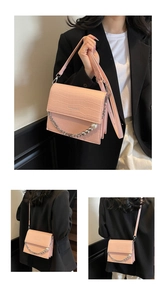 Detail view of pink crocodile pattern shoulder bag with metal chain and pearl charms