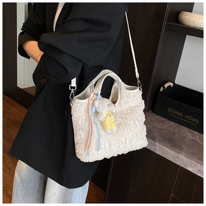 Détail du sac fourre-tout blanc en imitation peau de mouton avec un charmant petit ours