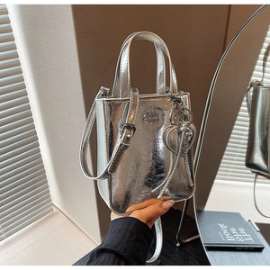 Détail du mini sac cabas argenté texturé avec breloque cœur et bandoulière réglable