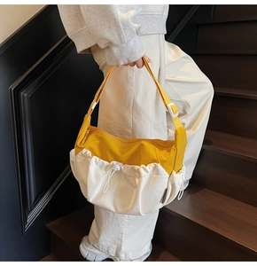 Detailed close-up of yellow and beige canvas dumpling bag with drawstring pockets