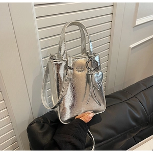 Détail du sac à main argenté en cuir PU métallisé avec breloque cœur et bandoulière