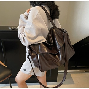 Close-up of vintage oil wax leather tote bag showing soft texture and metal buckle detail