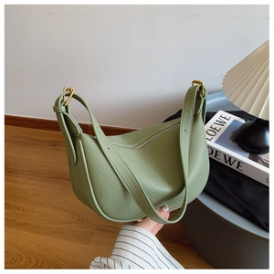 Detail of avocado green textured leather shoulder bag with matte gold metal buckle strap