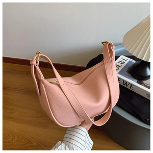 Detailed close-up of pink lychee grain leather shoulder bag with gold zipper and metal buckles