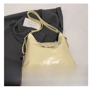 Détail du sac cabas en cuir crème avec bordures à volants et bandoulière en chaîne métal