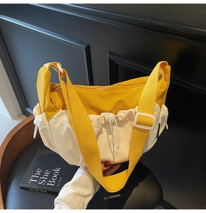 Detail of yellow canvas crossbody bag featuring side drawstring pocket and zip closure