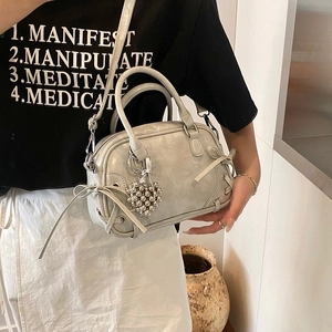 Schicke silberne Boston Bowling Tasche mit Herzanhänger und Schleife am Model