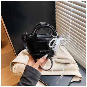 Mini black patent leather bucket bag with pearl and lace bow charm detail