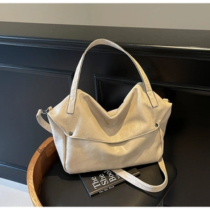 Detailed macro view of beige soft waxed leather texture and metal buckle on tote bag