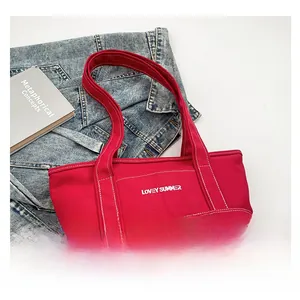 Detail of red canvas tote bag with white contrast stitching and Lovey Summer text