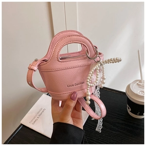 Pink mini handbag with pearl charms, lace bow, and glossy patent leather texture detail