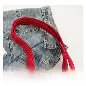 Close-up of red canvas tote bag showing wide handle with durable double stitching