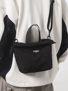 Versatile black nylon crossbody bag with drawstring closure and adjustable strap