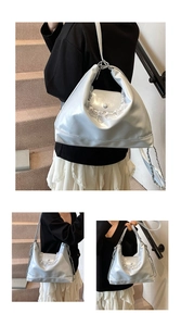 Détail d'un sac cabas argenté avec bordure en dentelle et chaîne décorative élégante