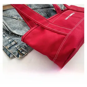 Detail of red canvas tote bag with contrast stitching and Lonely Summer text print