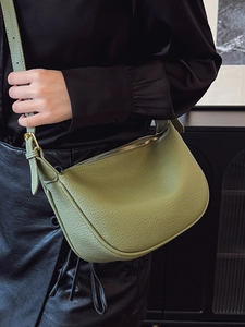 Olive green lychee pattern leather shoulder bag with gold hardware worn by a model