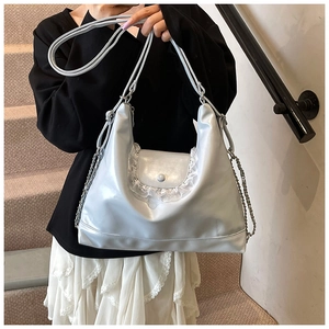 Détail du sac cabas en cuir métallisé argenté avec bordure en dentelle blanche délicate