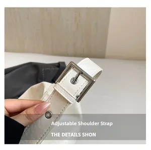 Detail of adjustable leather shoulder strap with silver square buckle and metal eyelets