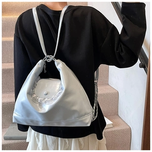 Détail du sac argenté en cuir avec bordure en dentelle porté à l'épaule