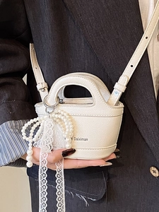 Mini white bucket bag with pearl lace bow charm and adjustable crossbody strap