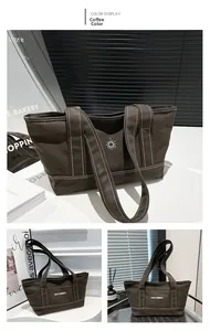 Detail of coffee brown canvas tote bag featuring summer sun embroidery and white stitching