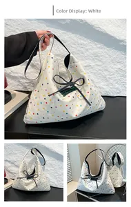 Detail of white canvas tote bag with colorful polka dots and a black ribbon bow