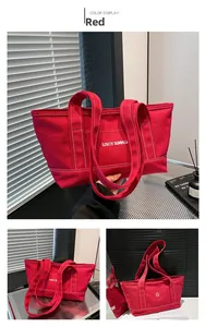 Detail view of red canvas tote bag with white stitching and Lovey Summer sun logo