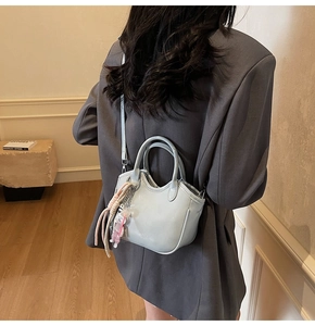Modelo con bolso tipo cubo verde menta con colgante de oso y borla decorativa