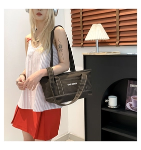 Detail of black canvas tote bag with contrast white stitching and LOVELY SUMMER print