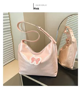 Detail of pink faux leather tote bag featuring a satin bow and delicate lace trim