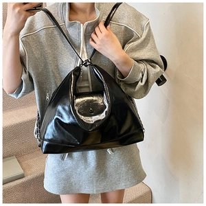 Détail du sac fourre-tout en cuir verni noir avec dentelle blanche et chaîne en métal
