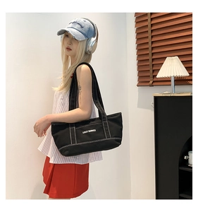 Detailed close-up of black canvas tote bag with white contrast stitching and Lovey Summer print