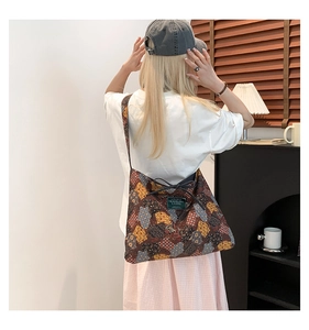 Close-up of ethnic patchwork tote bag with floral patterns and a canvas logo patch