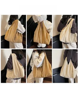 Detail showing high-capacity khaki and cream canvas tote bag with side pocket for daily commuting