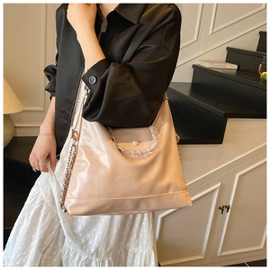Détail du sac cabas rose avec bordure en dentelle et bandoulière en chaîne métal