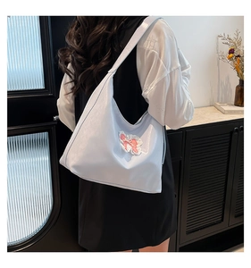 Detailed back view of a light blue glossy hobo bag with pink bow and lace embroidery