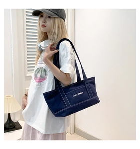 Detail of navy canvas tote bag with white Lovey Summer print and contrast stitching