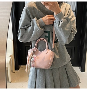 Selfie en el espejo con pequeño bolso tipo cubo rosa con dijes de oso y borla