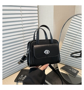 Dettaglio della mini borsa nera con chiusura a rotazione argento e finta pelle liscia