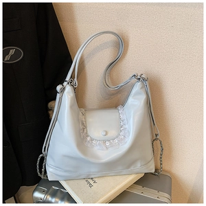 Détail du cabas gris clair avec bordure en dentelle blanche et bandoulière en chaîne