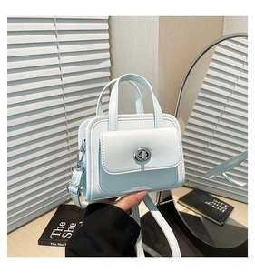 Dettaglio di piccola borsa quadrata in pelle azzurra con chiusura a scatto in metallo argento
