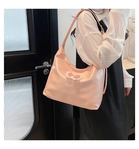 Close-up of pink Hobo bag with lace bow detail and soft pearlescent texture