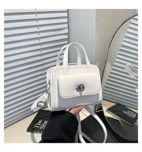 Dettaglio della mini borsa quadrata bianca con chiusura girevole argento e tracolla